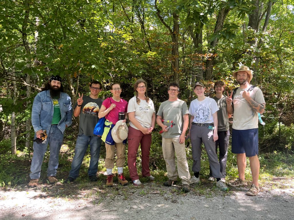 A group of volunters smiling and posing with tools after cutting honeysuckle in Garth Nature Area.
